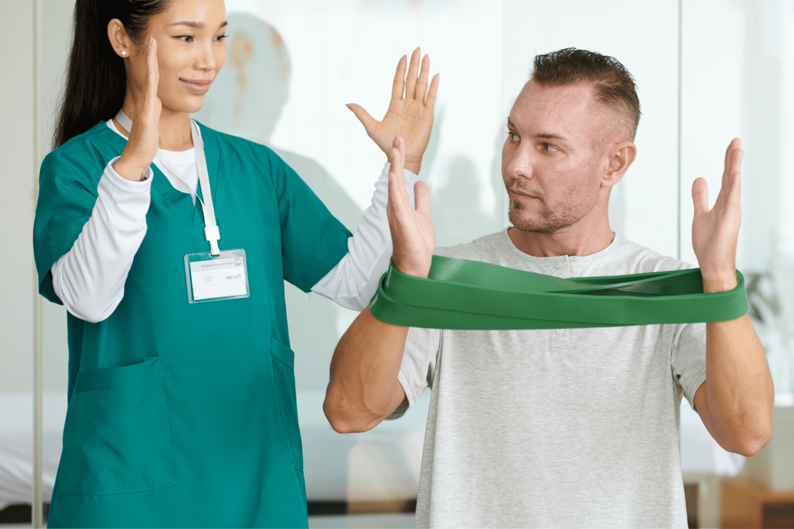 Physiotherapist shows a patient how to perform and exercise with a resistance band